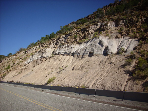 Road cut in
            Bandelier Tuff highlighting zeolitized zones
